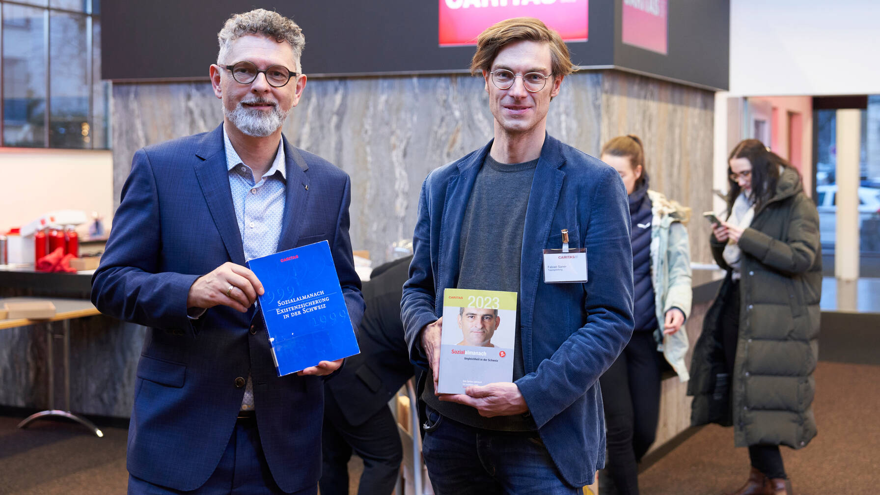 Peter Lack et Fabian Saner présentent la première et la 25e édition de l'Almanach social.