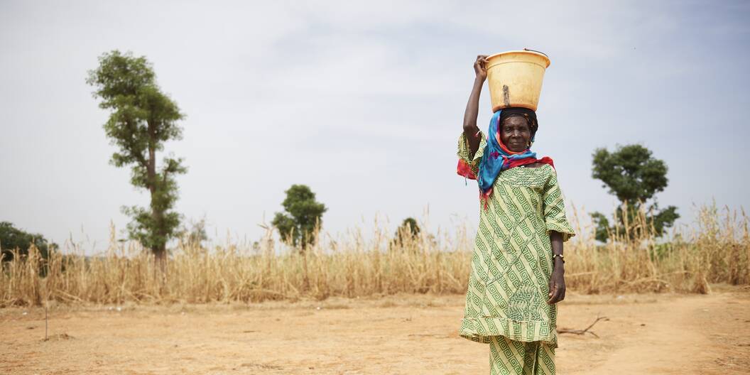Eine Frau steht in Mali auf dem Feld.